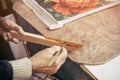 The carpenter paints a wooden blank to make a frame in his baguette workshop.