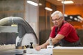 Carpenter with panel saw and fibreboard at factory Royalty Free Stock Photo