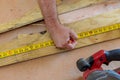 Carpenter with pencil in his hand measures the cutting board a tape measure Royalty Free Stock Photo