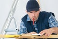 Carpenter with pencil in mouth holding part door