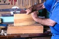 Carpenter planing a piece of wood in the workshop of his house Royalty Free Stock Photo