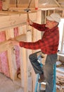 Carpenter pounding nail into interior wall