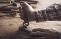 Carpenter removing rusty nails from old wooden planks