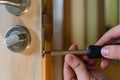 Carpenter repairing door lock. Installing a door handle. Handyman tightening door hinge . Hands of the repairman with a Royalty Free Stock Photo