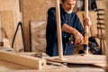 Carpenter repairing legs of a table with electric drill