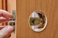 The carpenter replaces the door lock. Hole for handles into the wood interior door and brass latch