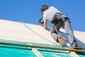 Builder at work with wooden roof construction. Royalty Free Stock Photo