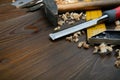 carpentry tools: chisel, hammer, building square with wood shavings on a wooden surface