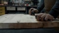 Carpenter`s hands in an apron and a piece of wood Royalty Free Stock Photo