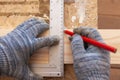 Carpenter`s hands with a corner and a pencil mark on the board Royalty Free Stock Photo