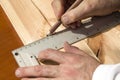 Carpenter`s hands indicate the dimension on the board with a pencil and an angle. Royalty Free Stock Photo