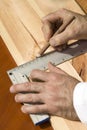 The carpenter`s hands indicate the dimension on the board with a pencil and an angle. Royalty Free Stock Photo