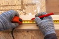 Carpenter`s hands with tape measure and cardash making a mark on the board Royalty Free Stock Photo