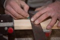 The carpenter`s rough hands draw a line on a wooden Board with a pencil and a square Royalty Free Stock Photo