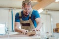 Carpenter sanding piece of wood by hand