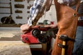 Carpenter sanding wood with belt sander at workshop in wooden board project or woodworking carpentry