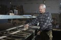 Carpenter Sanding Wood in Workshop