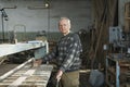 Carpenter Sanding Wood in Workshop