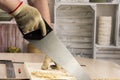 Carpenter sawing a board with a hand wood saw Royalty Free Stock Photo