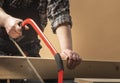 Carpenter sawing a board with a hand wood saw