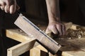 Carpenter sawing a board with a hand wood saw