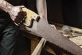 Carpenter sawing a board with a hand wood saw