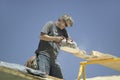 Carpenter sawing board on roof Royalty Free Stock Photo