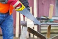 Carpenter sawing plank