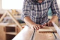 Carpenter sawing wood with a table saw in his workshop Royalty Free Stock Photo