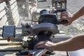 A carpenter saws off a board with a circular saw