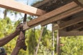 A carpenter saws off the excess edge of a wood rafter. Building or reconstructing a wooden roof frame for a rural home