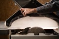 Carpenter saws wood on a table saw in his workshop. Male craftsman saws wood on a circular saw. Manufacture wooden Royalty Free Stock Photo