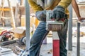 Carpenter is shaving red wood door by his shaving machine in outdoor field with steel pole building structure environment Royalty Free Stock Photo