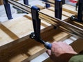 Carpenter squeezing, turning the wood clamp