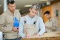 Carpenter supervising student in woodwork class Royalty Free Stock Photo