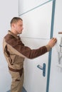 Carpenter Taking Measurement Of Door