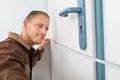 Carpenter Taking Measurement Of Door