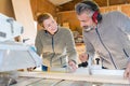 carpenter teaching apprentice how to cut wood