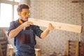 Carpenter testing wood plank evenness at workshop Royalty Free Stock Photo