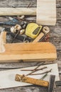 The carpenter tools on wooden bench, plane, chisel,mallet, tape measure, hammer, tongs, pliers, level, nails and a saw