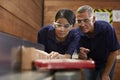 Carpenter Training Female Apprentice To Use Plane