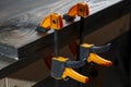 Carpenter two clamps are fixed to boards, closeup. Carpentry tools in the home workshop Royalty Free Stock Photo