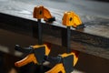 Carpenter two clamps are fixed to boards, closeup. Carpentry tools in the home workshop Royalty Free Stock Photo