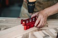 Carpenter use drill bit and centering dowel jig or pocket hole jig tool to make strong joints on wooden plate. woodworking concept Royalty Free Stock Photo