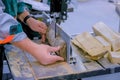 Carpenter using bandsaw tool, cutting piece of wood at workshop - close up Royalty Free Stock Photo