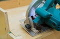 Carpenter using circular electro saw cutting kitchen furniture