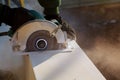 Carpenter using circular saw for cutting boards. Construction details of male worker Royalty Free Stock Photo