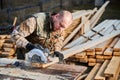 Carpenter using circular saw for cutting joist for building wooden frame house. Royalty Free Stock Photo