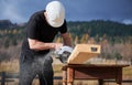 Carpenter using circular saw for cutting joist for building wooden frame house. Royalty Free Stock Photo