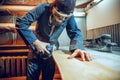 Carpenter using circular saw for cutting wooden boards. Royalty Free Stock Photo